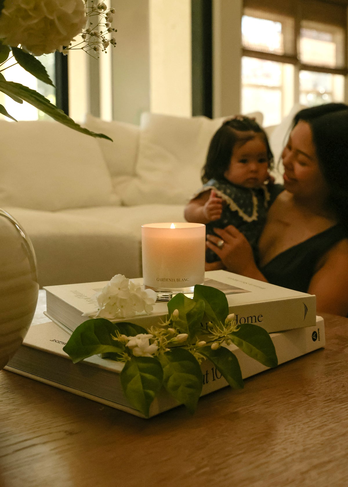 A parent and child at home surrounded by Chenda Studio candles
